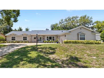 Charming single-story home with a well-manicured lawn and beautifully maintained landscaping at 2220 Derbyshire Rd, Maitland, FL 32751