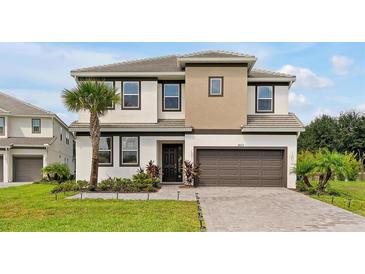 Beautiful two-story home features a well-manicured lawn, neutral color scheme, and attached two-car garage at 4429 Ganesha Loop, Kissimmee, FL 34746