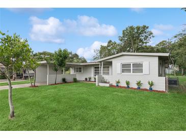 Charming one-story home with a green lawn, complemented by flowering plants and a well-maintained landscape at 941 Grey Oak Ct, Orlando, FL 32809