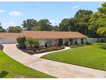 Single-story home featuring a lush front lawn, driveway, and mature landscaping at 1191 Banbury Trl, Maitland, FL 32751