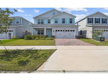 Charming two-story home with a well-manicured lawn and appealing curb appeal, showcasing a modern design at 2056 Airedale Way, Lake Alfred, FL 33850