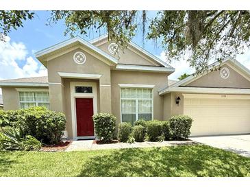 Charming single-story home featuring a red front door and well-maintained landscaping at 3539 Maple Ridge Loop, Kissimmee, FL 34741