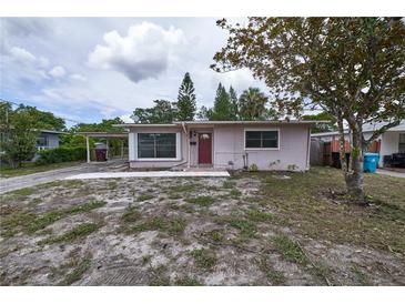 Charming single-story home with a red front door, carport, and partially xeriscaped front yard at 535 Romano Ave, Orlando, FL 32807