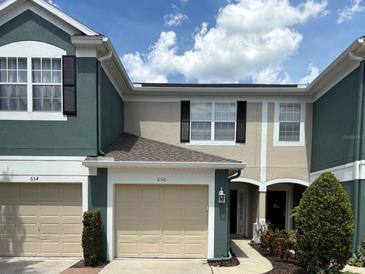 Charming townhome featuring a one-car garage and inviting facade with lush landscaping at 650 Shropshire Loop, Sanford, FL 32771