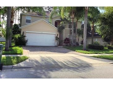 Charming two-story home boasts a paved driveway, attached garage, and mature palm tree landscaping in a desirable location at 1130 Burland Cir, Winter Garden, FL 34787