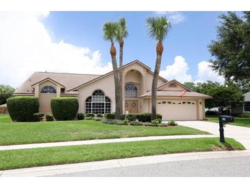 Charming beige home with manicured lawn, arched windows, and palm trees at 1546 Royal Cir, Apopka, FL 32703