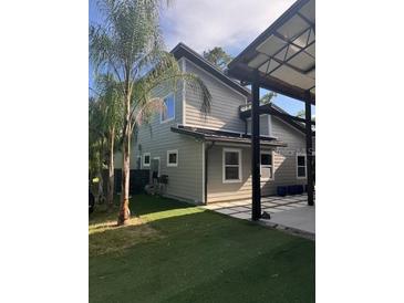 Beautiful side view of gray home with palm trees and nice landscaping at 2325 Audley St, Oviedo, FL 32765