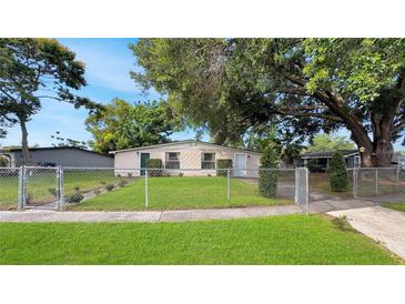 Charming home with a well-maintained lawn and a secure chain-link fence at 7810 Grevillea Dr, Orlando, FL 32822