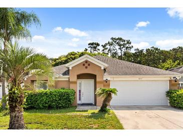 Charming single-story home with a well-manicured lawn and a two-car garage on a sunny day at 8852 Fort Jefferson Blvd, Orlando, FL 32822