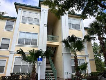 Condo building with stairs, palm trees, and a handicap parking sign in front at 8929 Legacy Ct # 208, Kissimmee, FL 34747