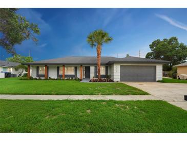 Charming single-story home featuring well-kept lawn, grey painted garage door, modern trim, and inviting curb appeal at 5938 Marlberry Dr, Orlando, FL 32819