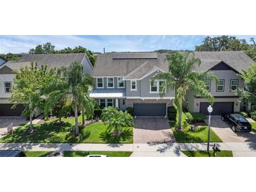 Beautiful two-story home with a paver driveway, lush landscaping, and a two-car garage at 617 Marsh Reed Dr, Winter Garden, FL 34787