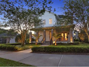 Charming two-story home with a welcoming front porch, stone columns, and manicured landscaping at 8665 Pinter St, Orlando, FL 32827
