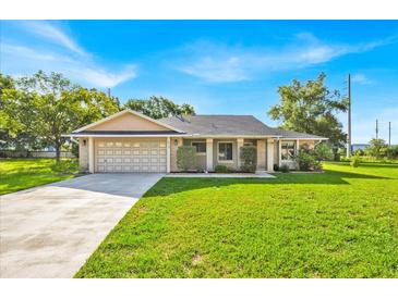 Charming single-story home with a well-manicured lawn and attached two-car garage at 910 Amy Ridge Ct, Kissimmee, FL 34747