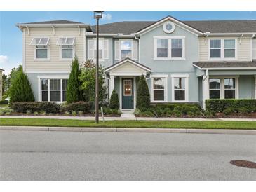 Charming townhome with a well-manicured lawn and colorful exterior paint at 10009 Randal Walk St, Orlando, FL 32832