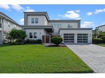 Modern two-story home with well-manicured lawn and three-car garage at 14124 Eliot Ave, Orlando, FL 32827