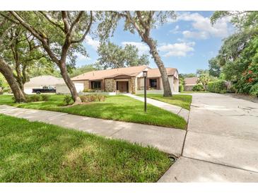 Attractive single-story home with stone accents, complemented by a well-maintained lawn and mature trees at 1424 Mt Laurel Dr, Winter Springs, FL 32708