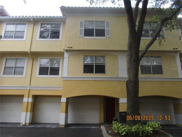 Attractive townhome featuring white trim, a red front door and a convenient drive-in garage at 1960 Legacy Cove Dr, Maitland, FL 32751
