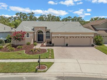 Charming single-story home with a three-car garage, manicured lawn, and beautiful landscaping at 219 Isle Of Sky Cir, Orlando, FL 32828