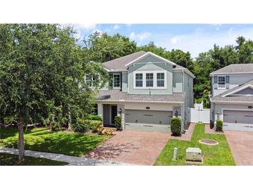 Inviting two-story home with a brick driveway and lush, green landscaping and a two car garage at 2621 Peony Dr, Oviedo, FL 32766