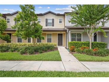 Charming two-story townhome with manicured landscaping, healthy plants, and a welcoming walkway at 5030 Caspian St, St Cloud, FL 34771