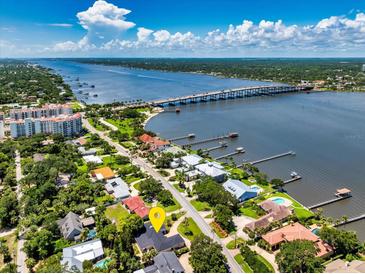 Stunning aerial view of a waterfront home near a bridge with lush landscaping and a beautiful waterway at 105 John Anderson Dr, Ormond Beach, FL 32176