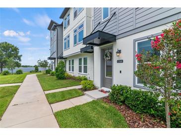 Charming townhome featuring a welcoming front yard and modern architectural details at 12468 Koshiba Aly, Orlando, FL 32827