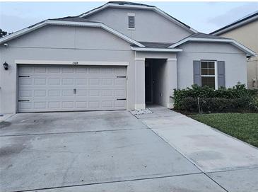 Charming single-story home with a gray exterior, a two-car garage and a well maintained driveway at 1588 Diamond Loop Drive, Kissimmee, FL 34744
