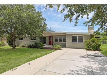 Charming single-story home featuring a brick exterior, mature landscaping, and a long driveway to the front entrance at 203 E Lakeview Ave, Eustis, FL 32726