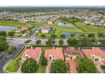 Stunning aerial view of a residential area with multiple homes, a pond, and lush green spaces at 2209 Callaway Ct, Davenport, FL 33837