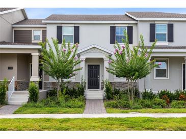 Charming townhome featuring well-manicured landscaping, a welcoming front porch, and classic architectural details at 3099 Ella Way, St Cloud, FL 34771