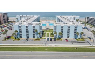 Stunning aerial view of the oceanfront condo complex with community pool and manicured grounds at 4151 S Atlantic Ave # 5110, New Smyrna Beach, FL 32169