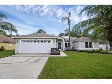 Charming single-story home with a two-car garage, well-manicured lawn, and tropical landscaping at 705 Sunburst Cove Ln, Winter Garden, FL 34787