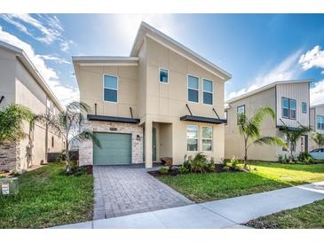 Modern two-story home with stylish facade, beautiful landscaping, and a two-car garage at 8982 Cabot Cliffs Dr, Davenport, FL 33896