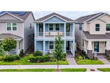 Charming two-story home with blue exterior, balcony, well-manicured lawn, and inviting curb appeal at 15133 Summer Harvest St, Winter Garden, FL 34787