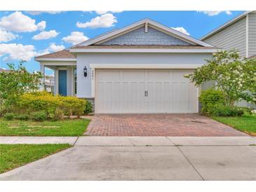 Charming single-story home with a brick driveway and attached two-car garage at 2601 Blowing Breeze Ave, Kissimmee, FL 34744