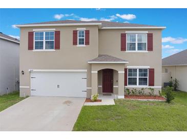 Inviting two-story home featuring a well-maintained lawn and a two-car garage at 4644 Bernard Blvd, Haines City, FL 33844