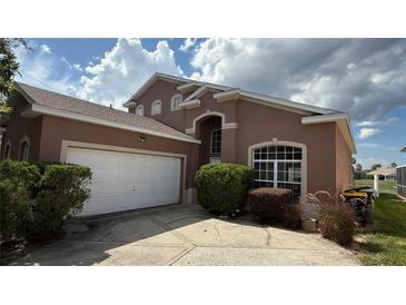 Charming home with a well-maintained lawn, large driveway, and a two-car garage at 513 Bailey Cir, Davenport, FL 33897