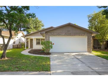 Charming home with a two-car garage, stone accents, and fresh landscaping, ready for move-in at 10519 Wyndcliff Dr, Orlando, FL 32817