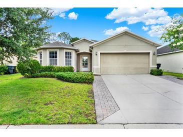 Charming single-story home featuring a well-manicured lawn and a two-car garage at 2216 Sequoia Way, Davenport, FL 33896