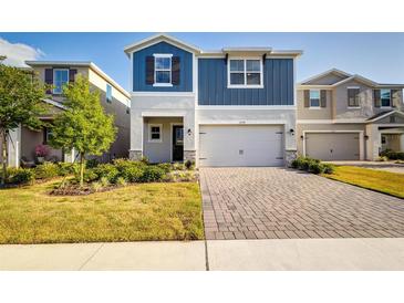 Charming two-story home featuring a two-car garage, a brick driveway, and a manicured lawn with shrubs at 2354 Emerald Springs Dr, Apopka, FL 32712