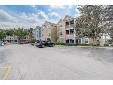Exterior view of a condominium complex with ample parking at 3428 Soho # 301, Orlando, FL 32811