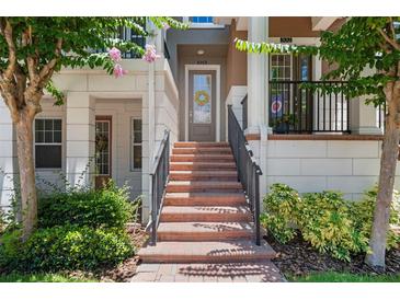 Inviting front entrance with brick steps and black railing, adding curb appeal to the property at 528 Lanark Ct, Orlando, FL 32806
