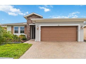 Charming single-story home featuring a stone accent wall and a two-car garage at 911 Tidal Pond Dr, Groveland, FL 34736