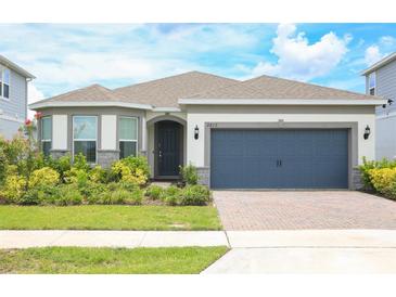 Charming single-Gathering home featuring a well-maintained lawn and a two-car garage at 2612 Summer Clouds Way, Kissimmee, FL 34744