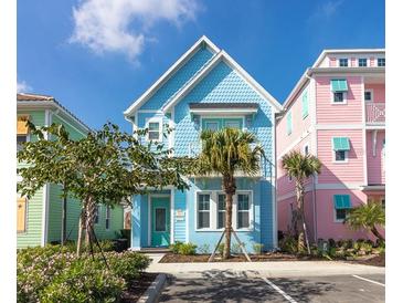 Charming two-story home with colorful exterior, front yard, and sunny sky at 3004 Latitude Ln, Kissimmee, FL 34747