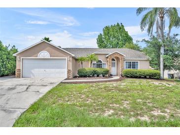 Charming single-story home features a stone-accented facade and a well-maintained lawn at 335 Oakpark Loop, Davenport, FL 33837