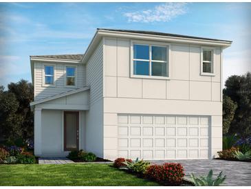 Contemporary two-story home featuring a two-car garage, neutral colors, and manicured landscaping at 3686 Portsmouth Ln, Haines City, FL 33844
