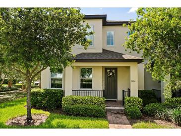 Charming two-story home featuring manicured landscaping, a welcoming porch, and a dark-colored front door at 9814 Amber Chestnut Way, Winter Garden, FL 34787