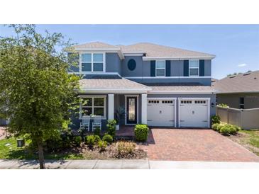 Charming two-story home with a well-manicured lawn and brick driveway at 15716 Sweet Lemon Way, Winter Garden, FL 34787